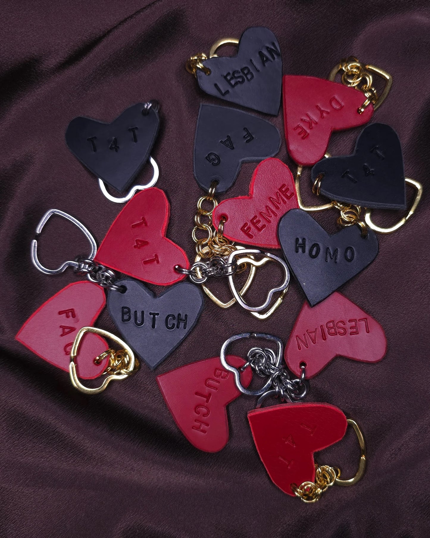 pile of heart shaped key chains with lgbt terms written