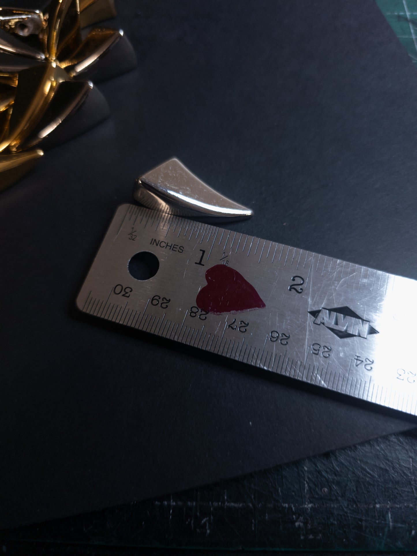 Metal ruler with claw shaped spike next to it
