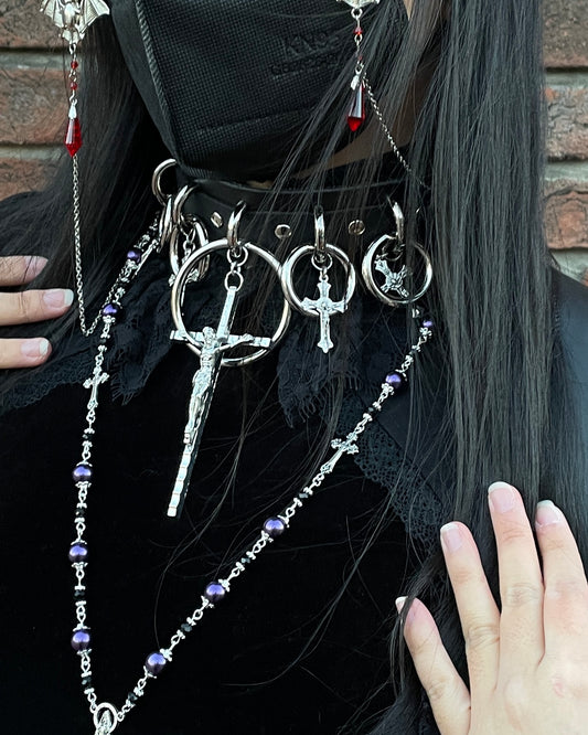 person wearing black and silver choker with large cross