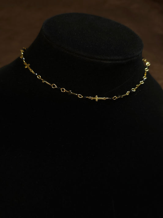 Gold necklace on a black mannequin head against a dark background