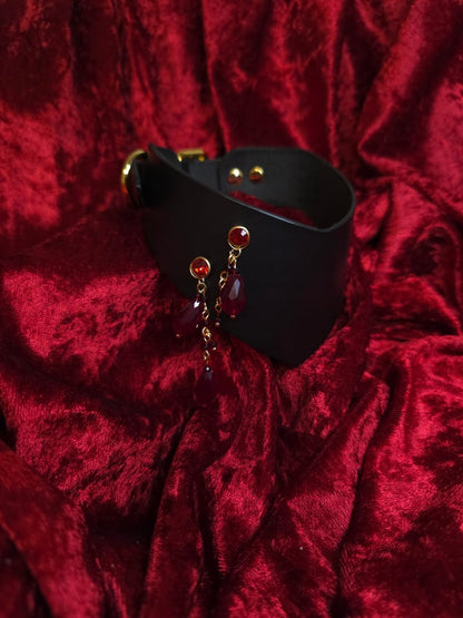 Black leather collar with red beads on a red textured background
