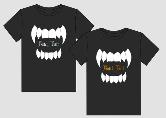 Two black t-shirts with a graphic design of fangs and text on a light gray background.