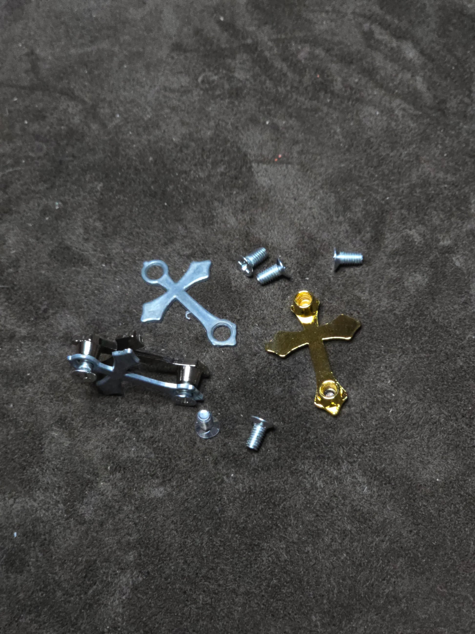 Metallic cross-shaped objects on a textured dark surface