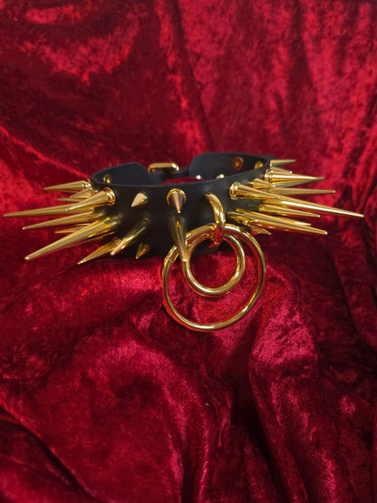 Black leather collar with gold spikes on a red velvet background