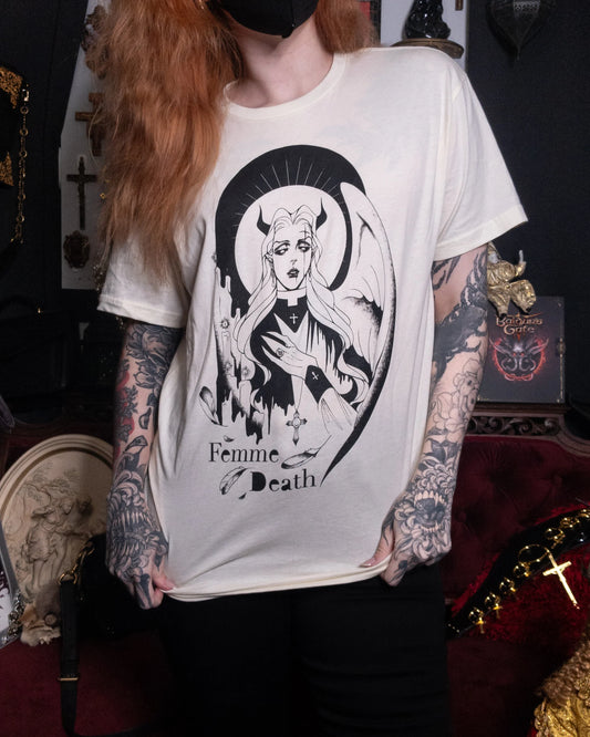 person wearing cream graphic tee shirt with black illustration, with ginger hair and tattoos