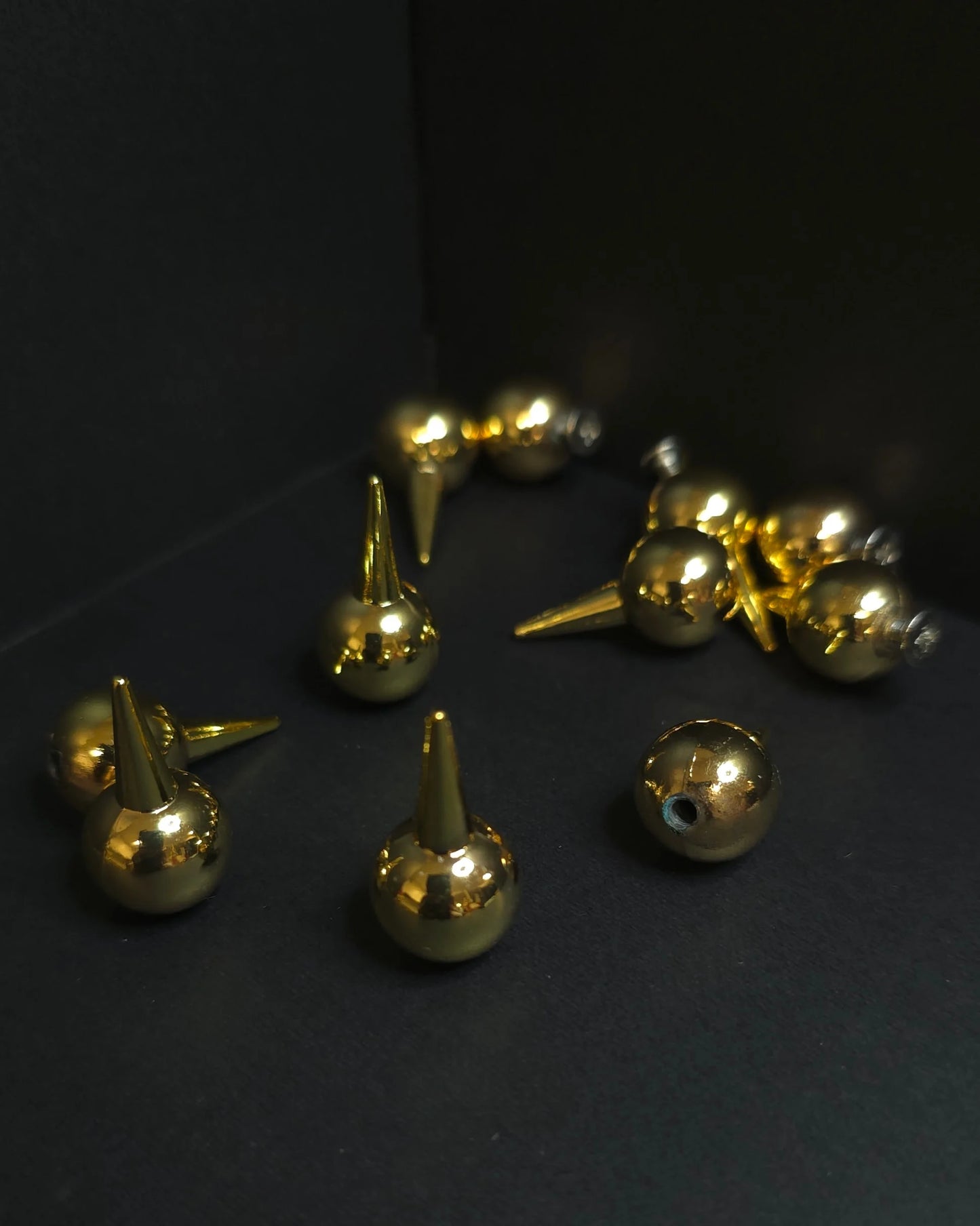 Gold metallic studs on a dark background