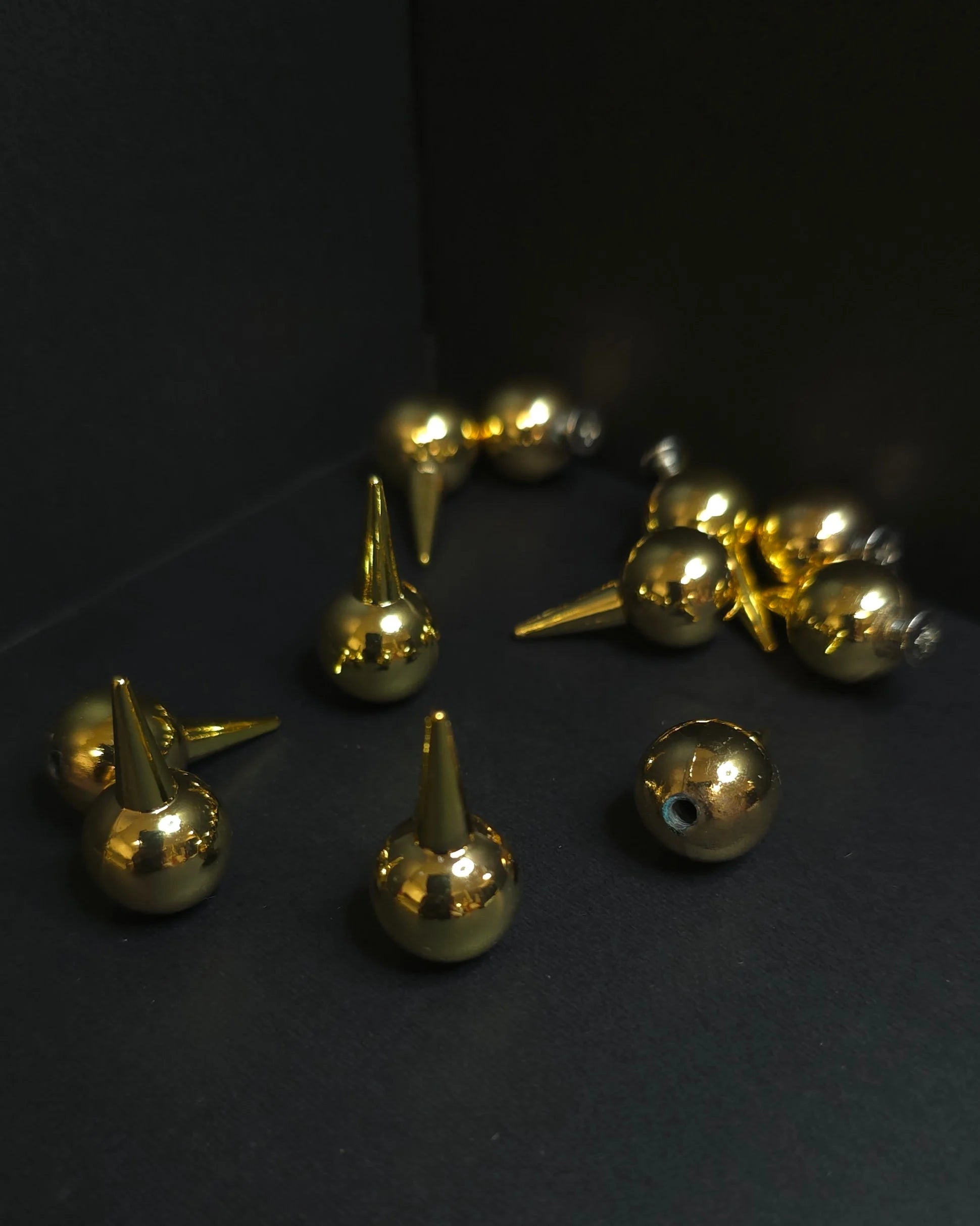 Gold metallic studs on a dark background