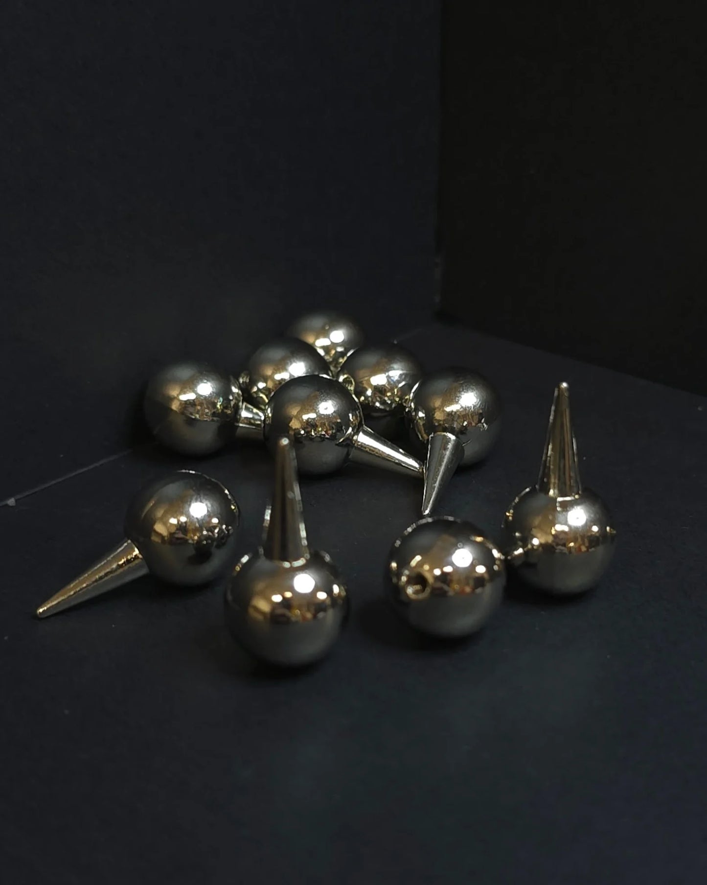 Metallic spherical objects with spike-like extensions on a black background