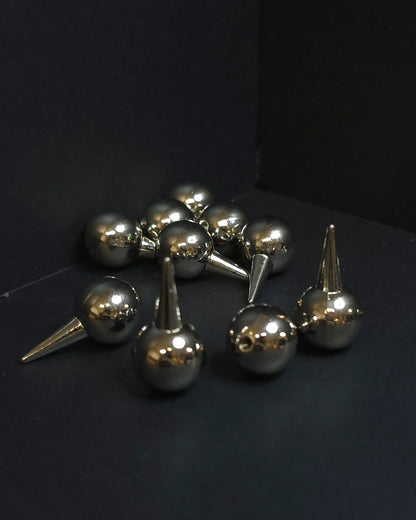 Metallic spherical objects with spike-like extensions on a black background