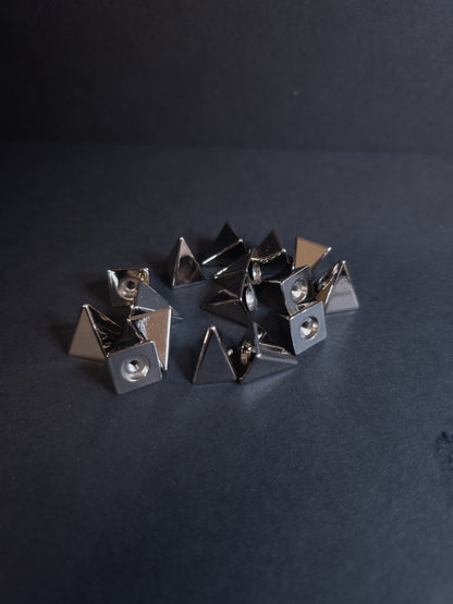Set of metallic pyramid-shaped studs on a dark background
