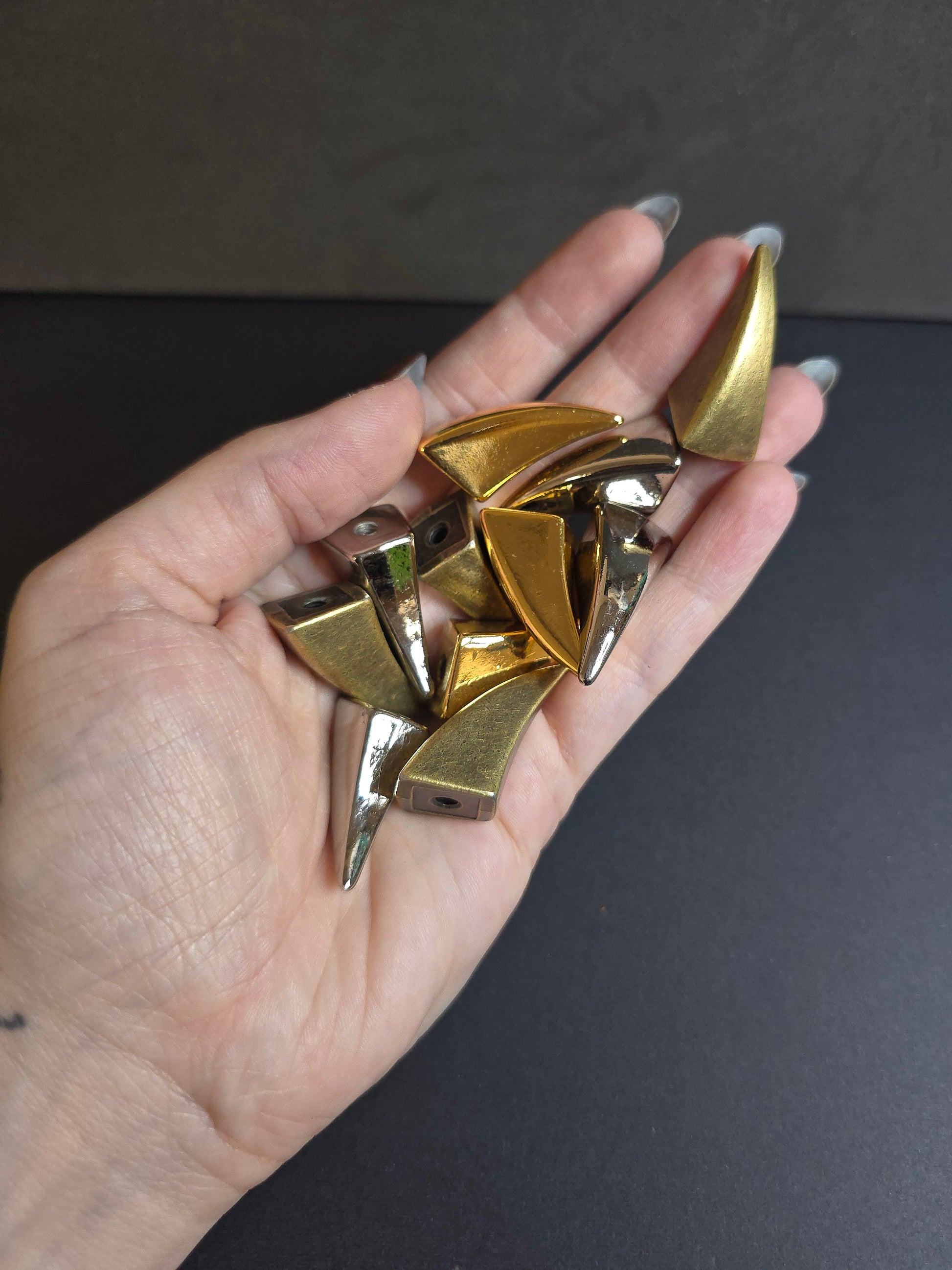 hand holding claw shaped spikes