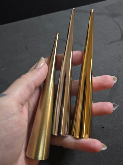 hand holding gold silver and bronze giant spikes
