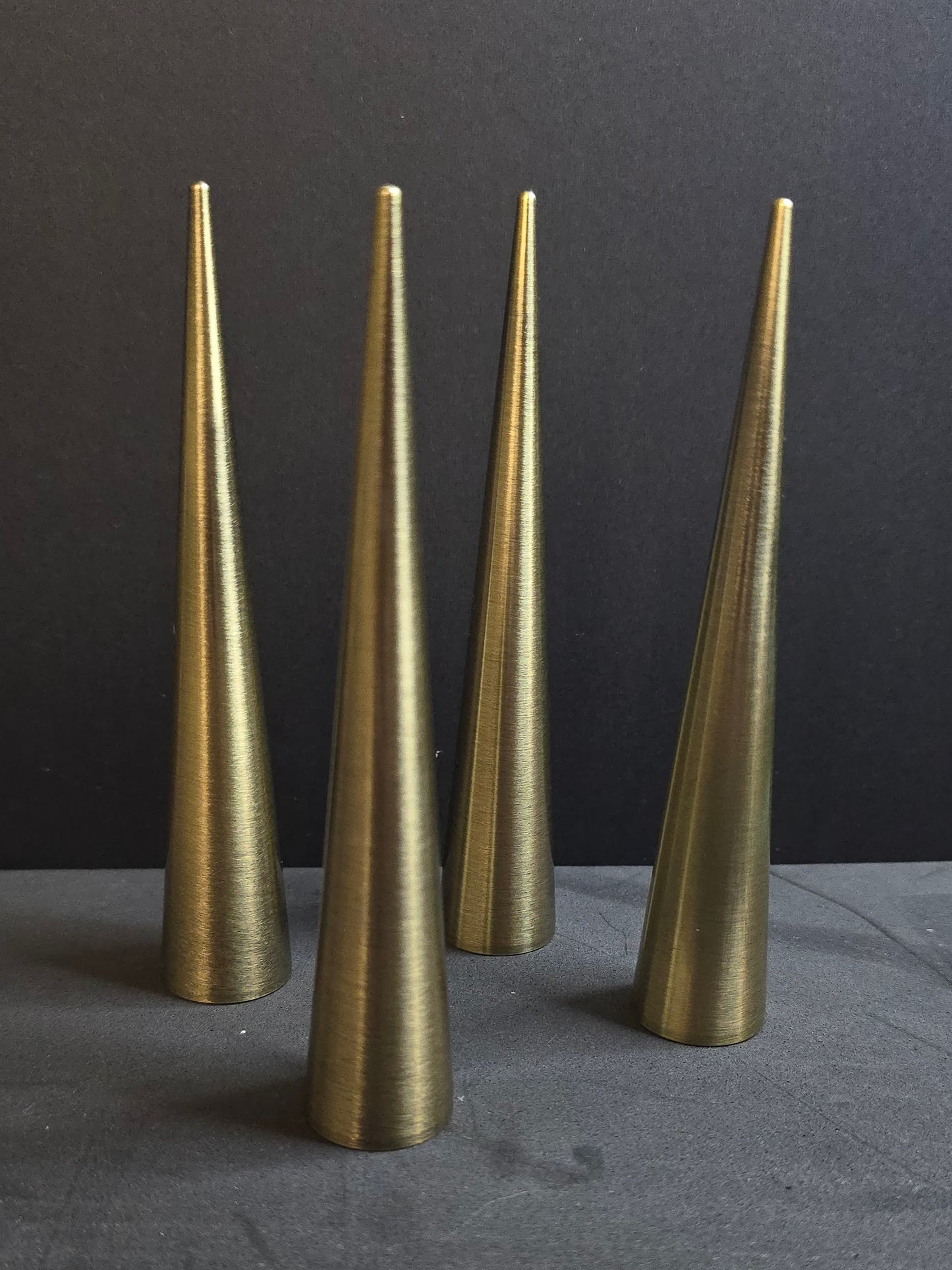 four bronze colored spikes on black background