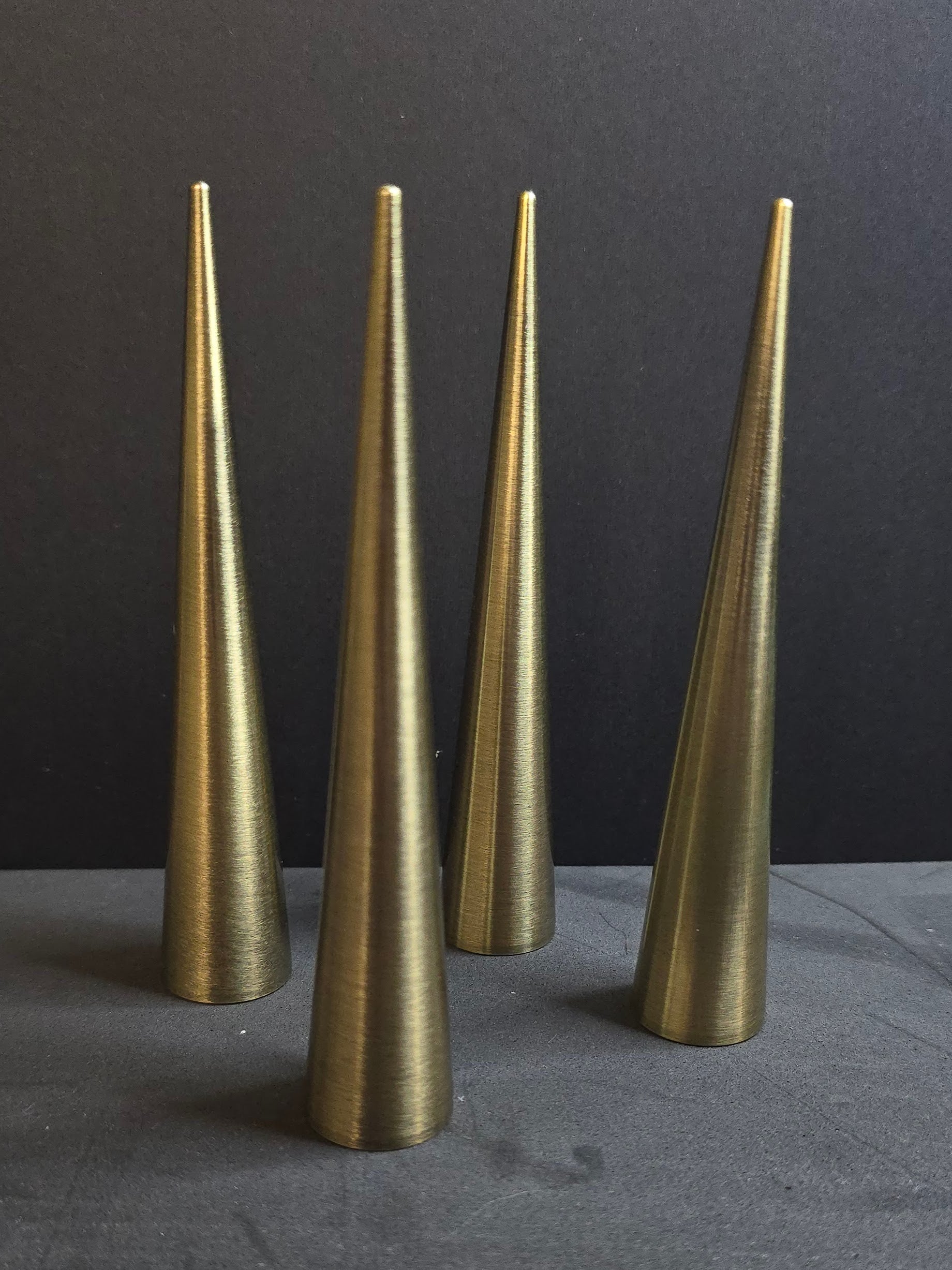 four bronze colored spikes on black background