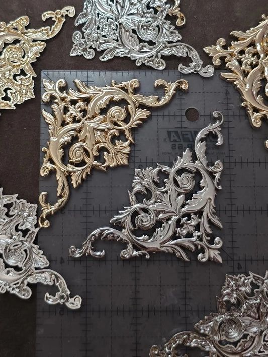 Decorative metal corner pieces on a black surface