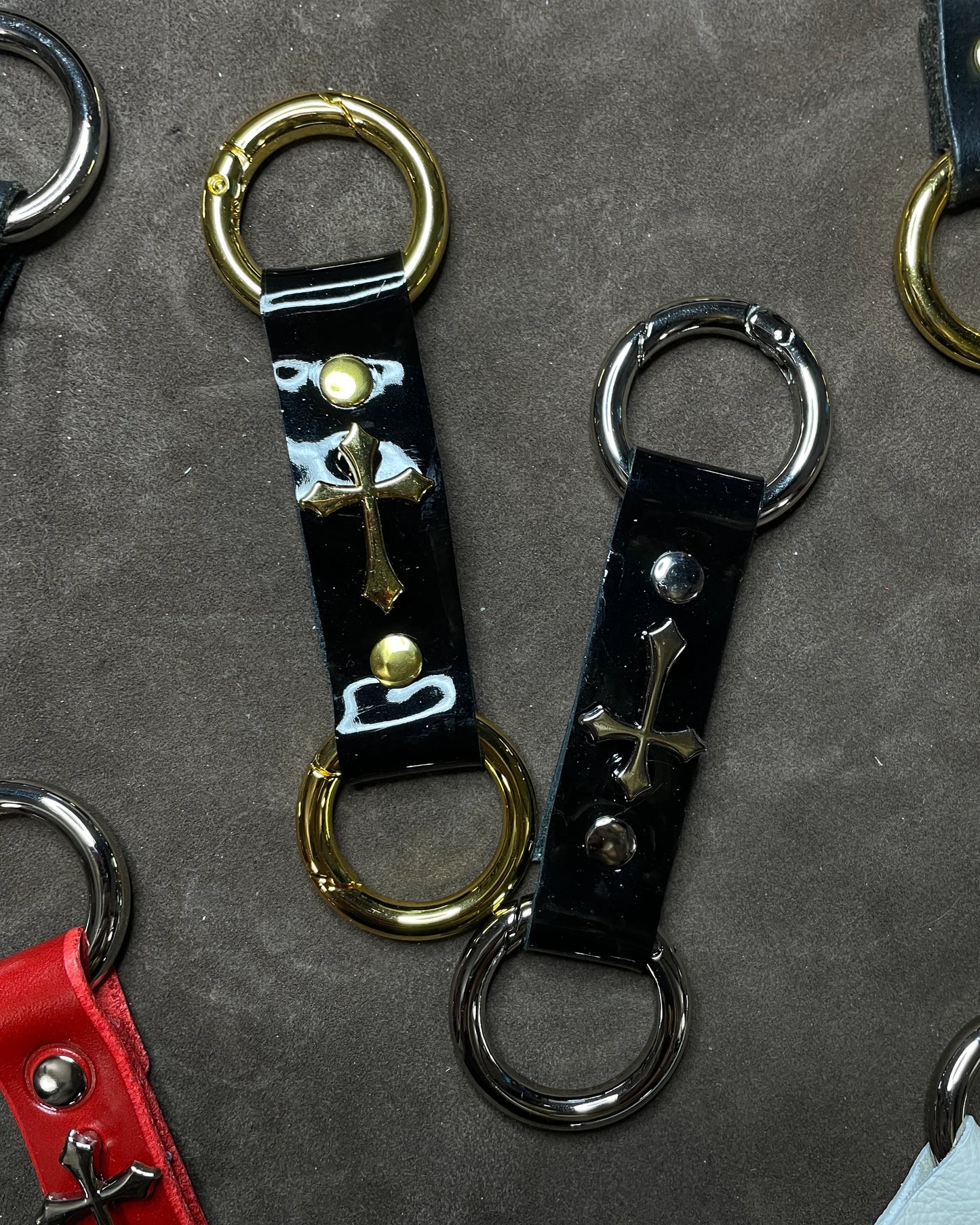 Collection of leather keychains with metal clasps on a gray surface
