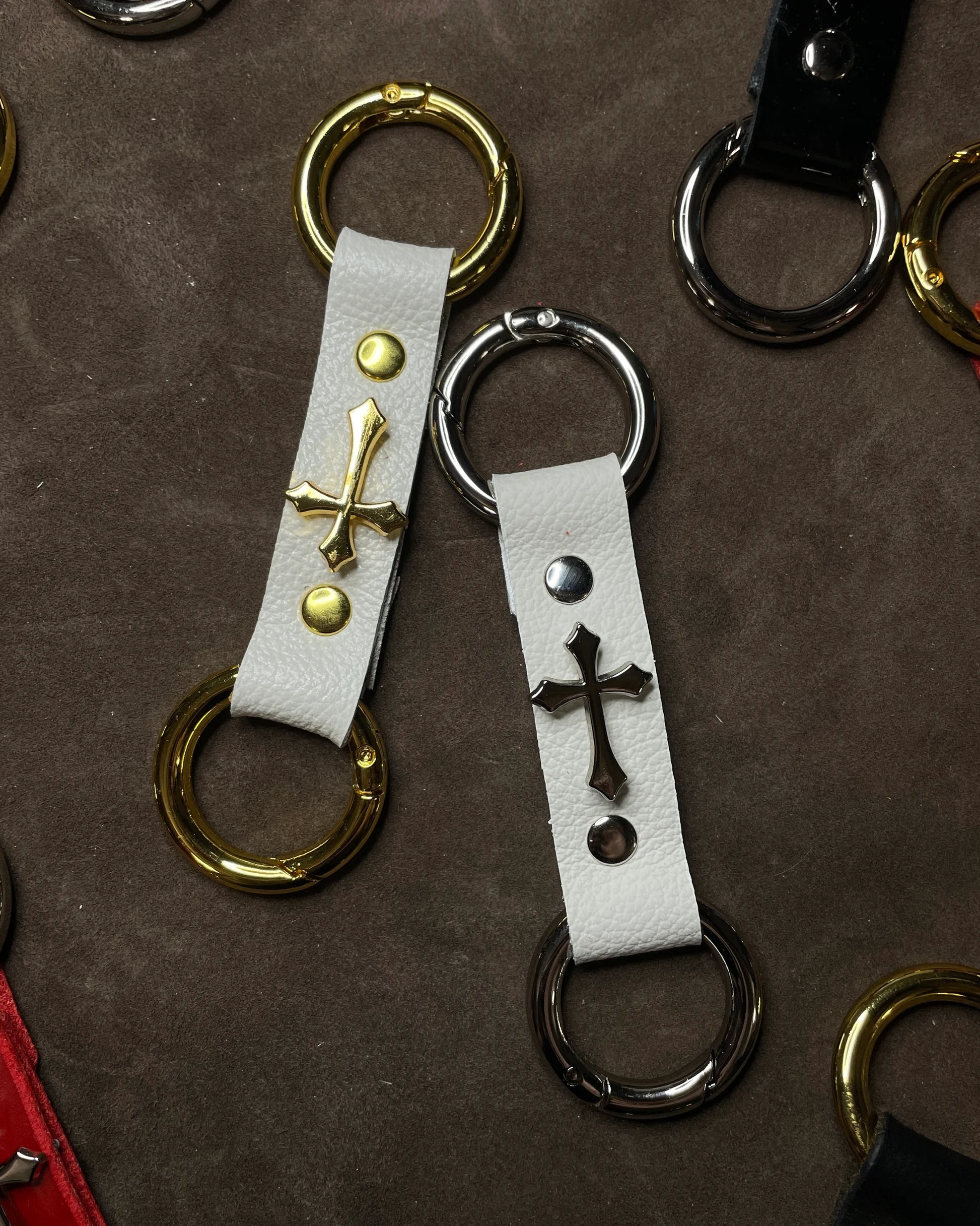 Keychains with cross designs on a brown leather surface