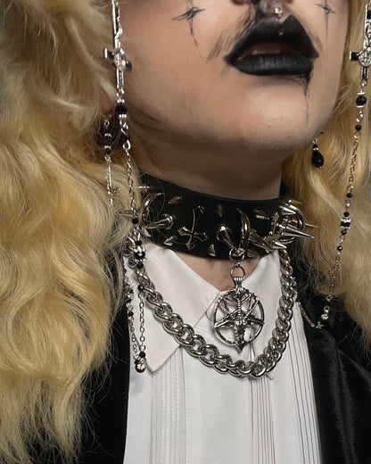 Person wearing a black choker with chain accessories and blonde hair.