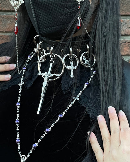 person wearing black and silver choker with large cross