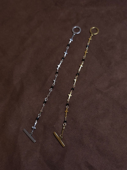 Two bracelets, one silver and one gold, on a brown fabric background
