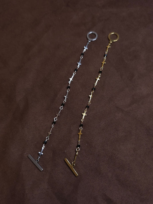 Two bracelets, one silver and one gold, on a brown fabric background
