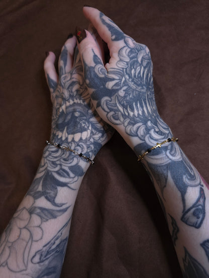 Tattooed arms with intricate designs on a brown background