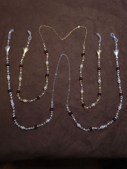 Two beaded glasses chains in silver and gold on brown background
