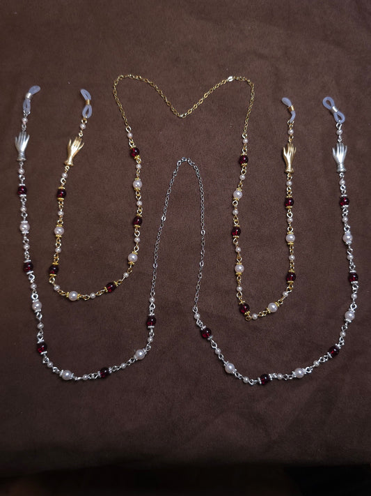 Two beaded glasses chains in silver and gold on brown background